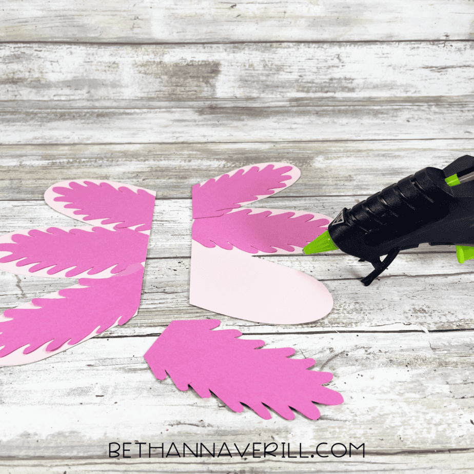 Hot glue gun attaching gills to sides of the paper plate.