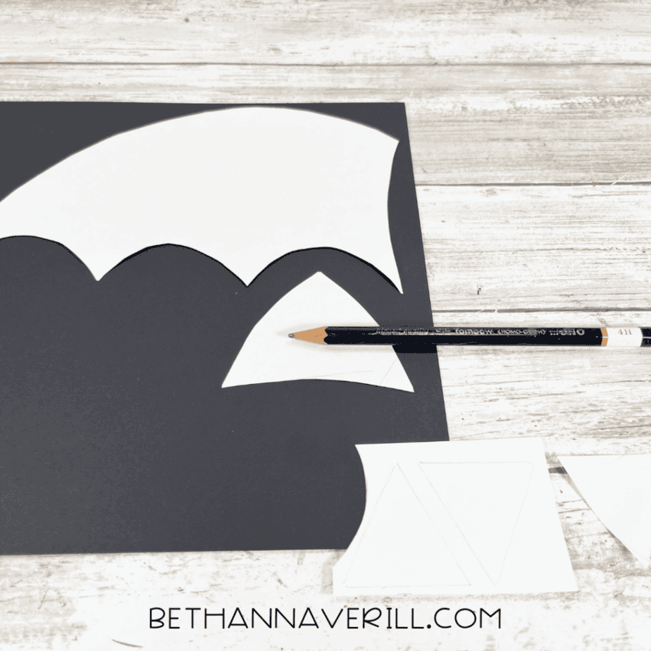 White templates traced onto black construction paper with a pencil for bat wings and ears.