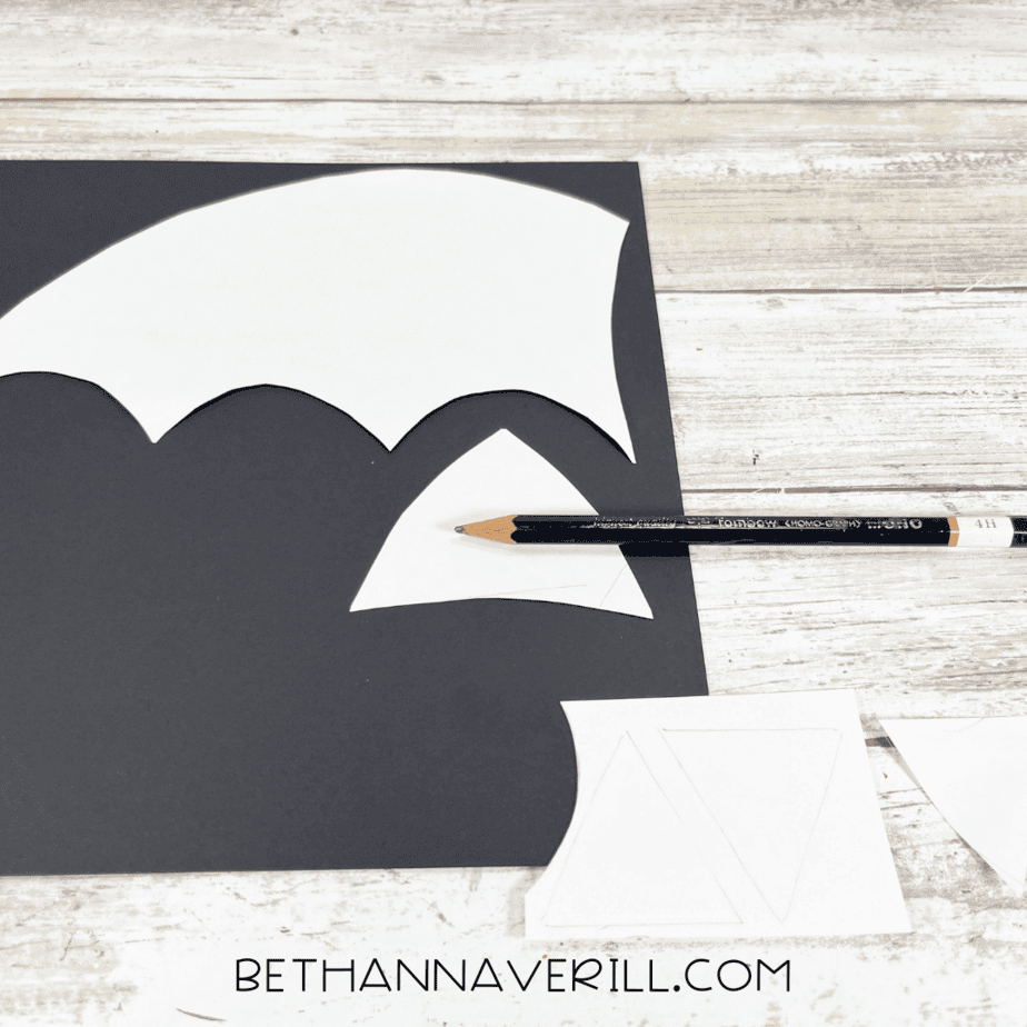 White templates traced onto black construction paper with a pencil for bat wings and ears.
