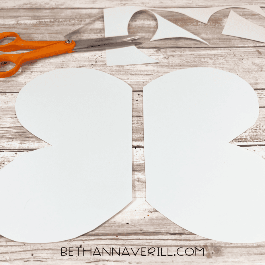 Cut out blue paper wings next to scissors.