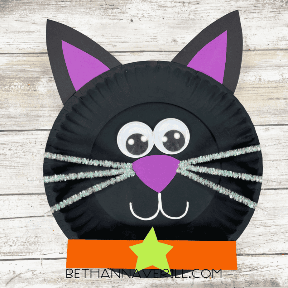 Finished black cat paper plate craft with collar and face details.