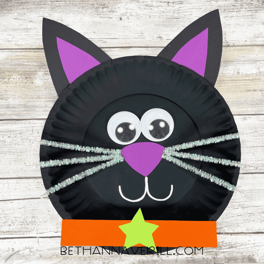 Finished black cat paper plate craft with collar and face details.