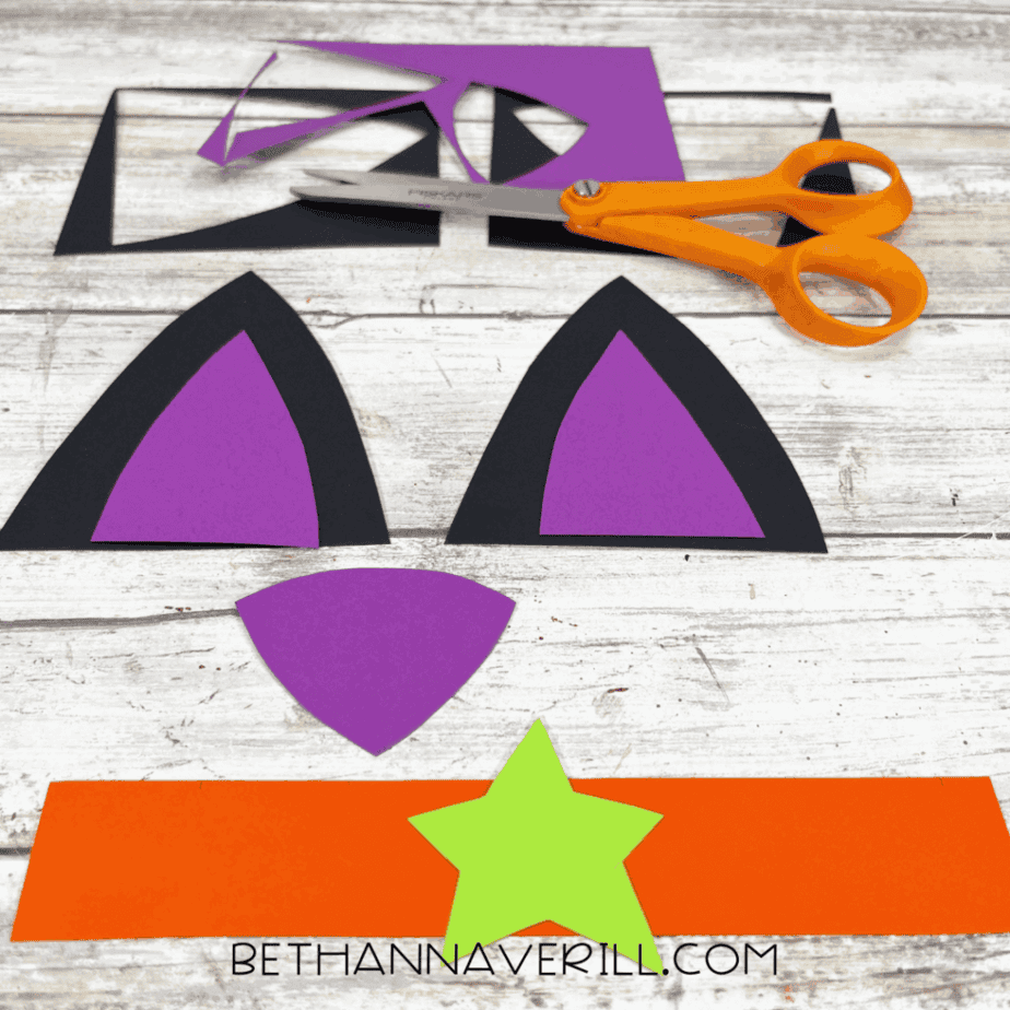 Cut-out paper ears, nose, star, and collar ready for assembly.