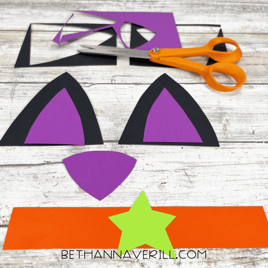 Cut-out paper ears, nose, star, and collar ready for assembly.