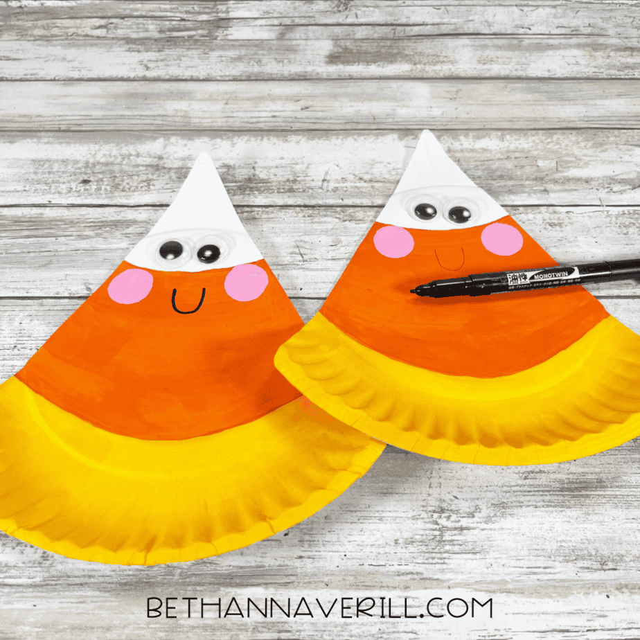 Smiling face drawn onto candy corn crafts with a black marker.