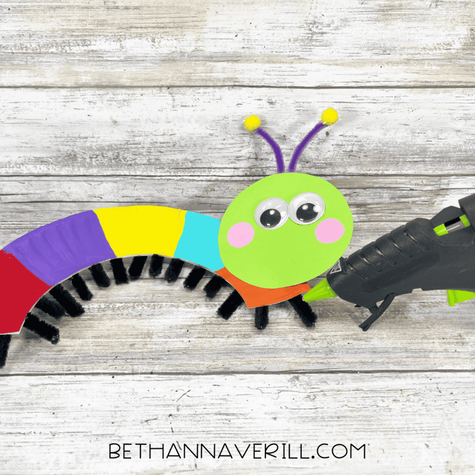 Caterpillar body with painted plate and green head being glued together.