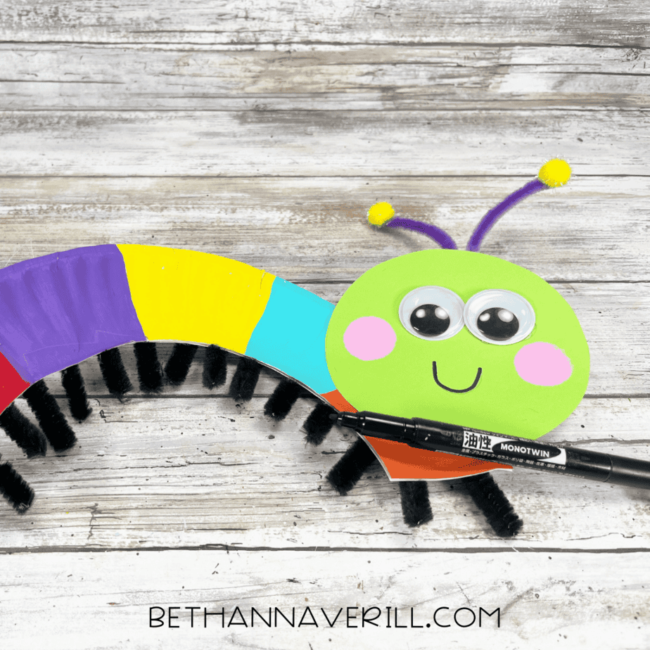 caterpillar with antennae attached, smiling face drawn with marker.