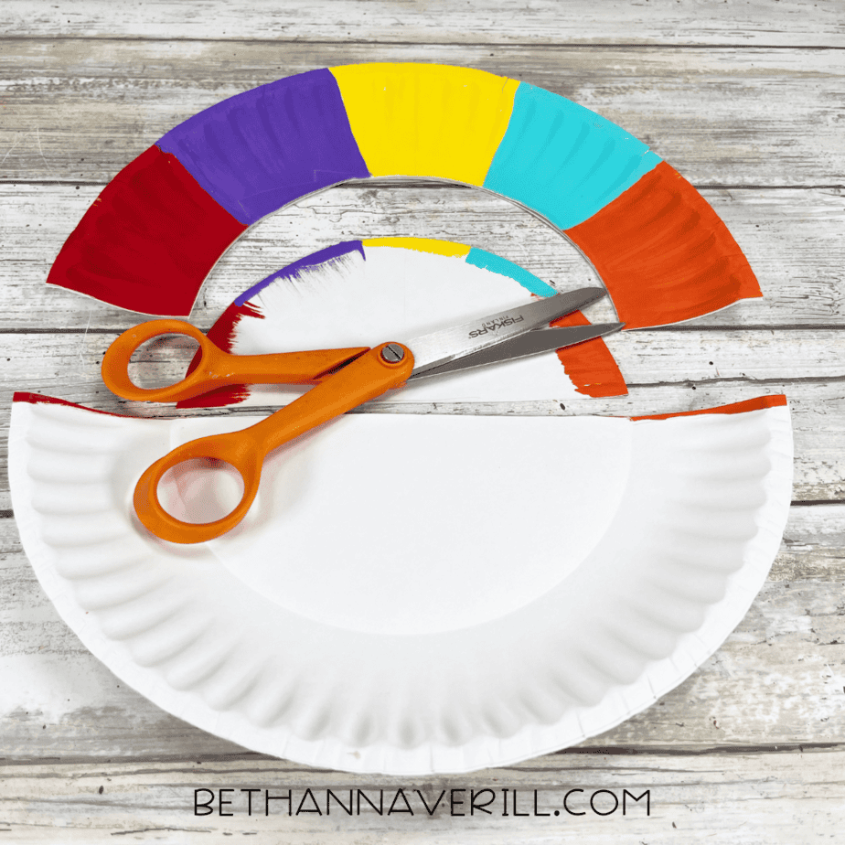 Painted paper plate cut in half with scissors.