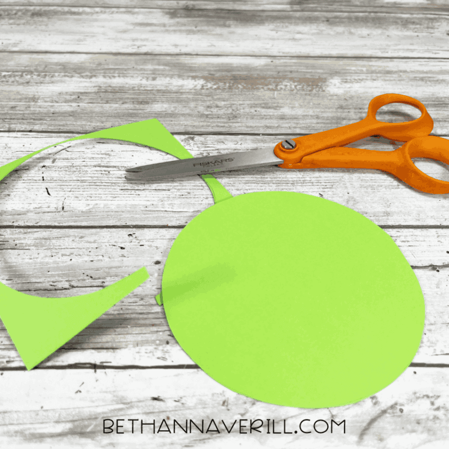 Green circle cut out of construction paper with scissors.
