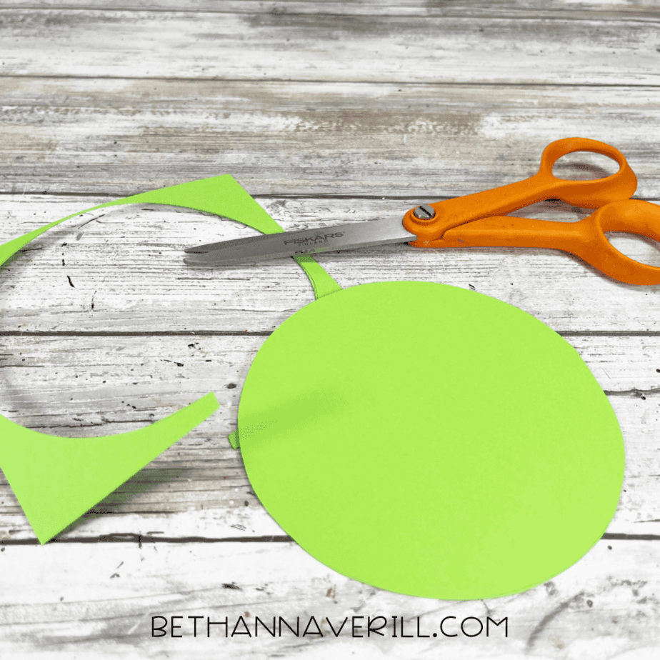 Green circle cut out of construction paper with scissors.