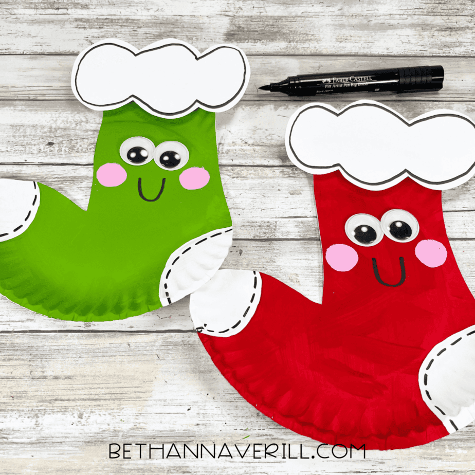 Finished stockings with black smiles drawn on and decorative lines around heel, toe, and top.