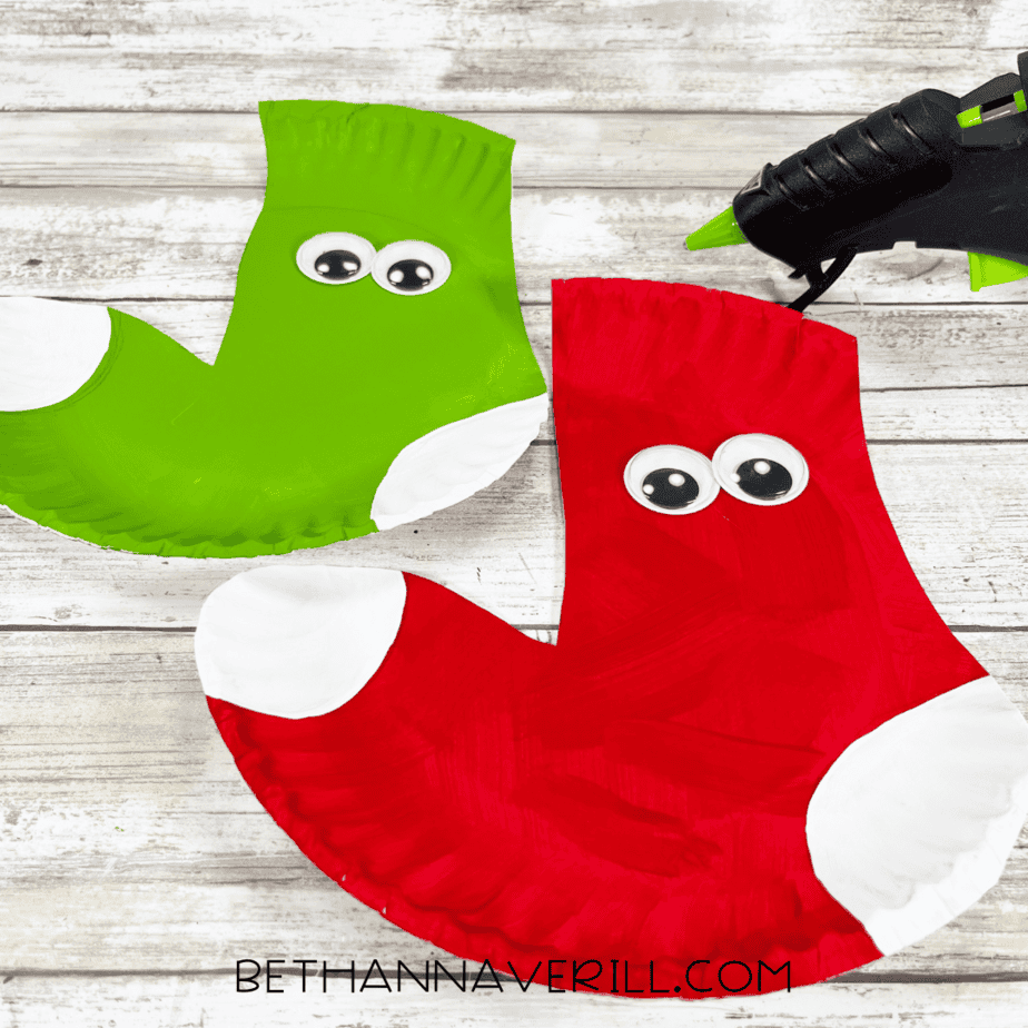 Red and green paper plate stockings with googly eyes glued on.