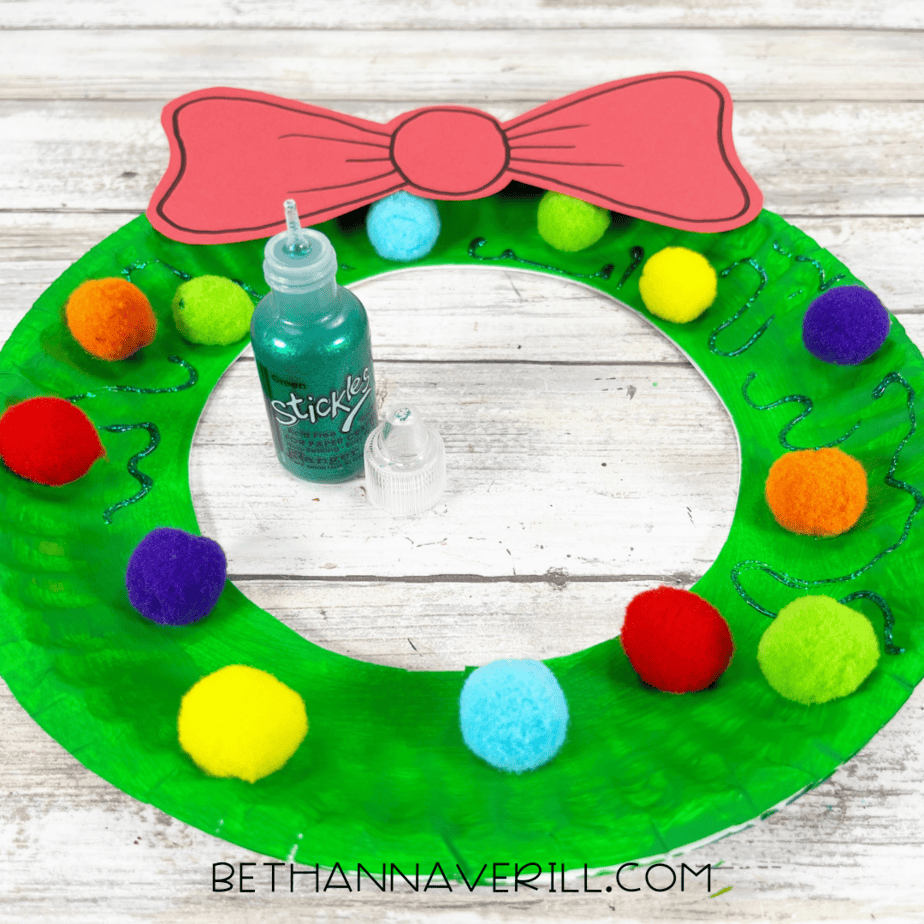 Glitter glue bottle adding sparkly accents to the wreath.