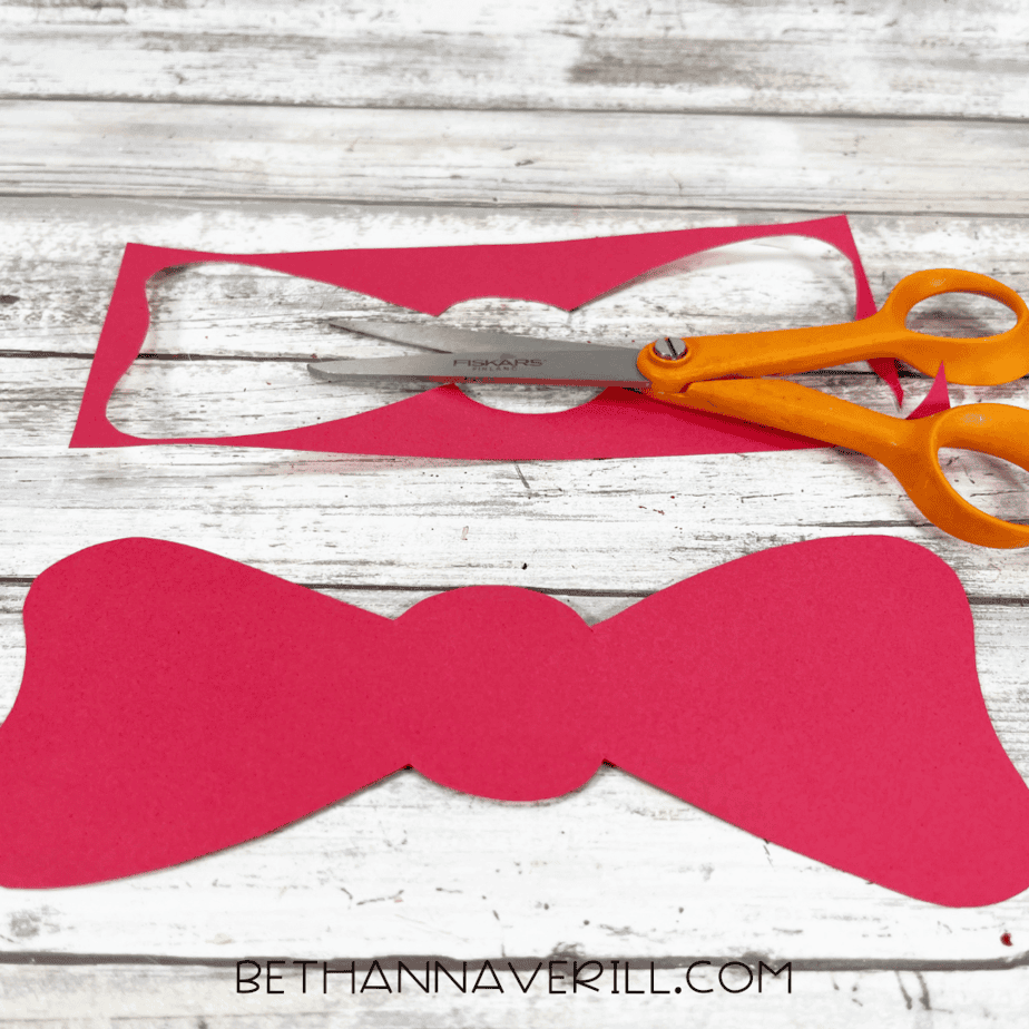 Red paper bow cut out with scissors.