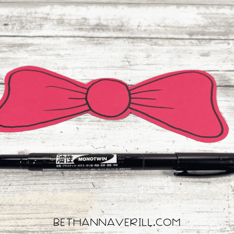 Red paper bow outlined and detailed with a black marker.