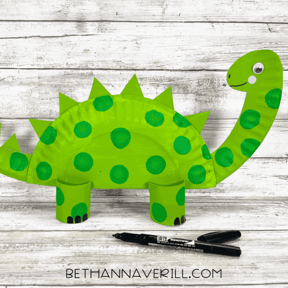 dinosaur paper plate craft with spikes, legs, and face.
