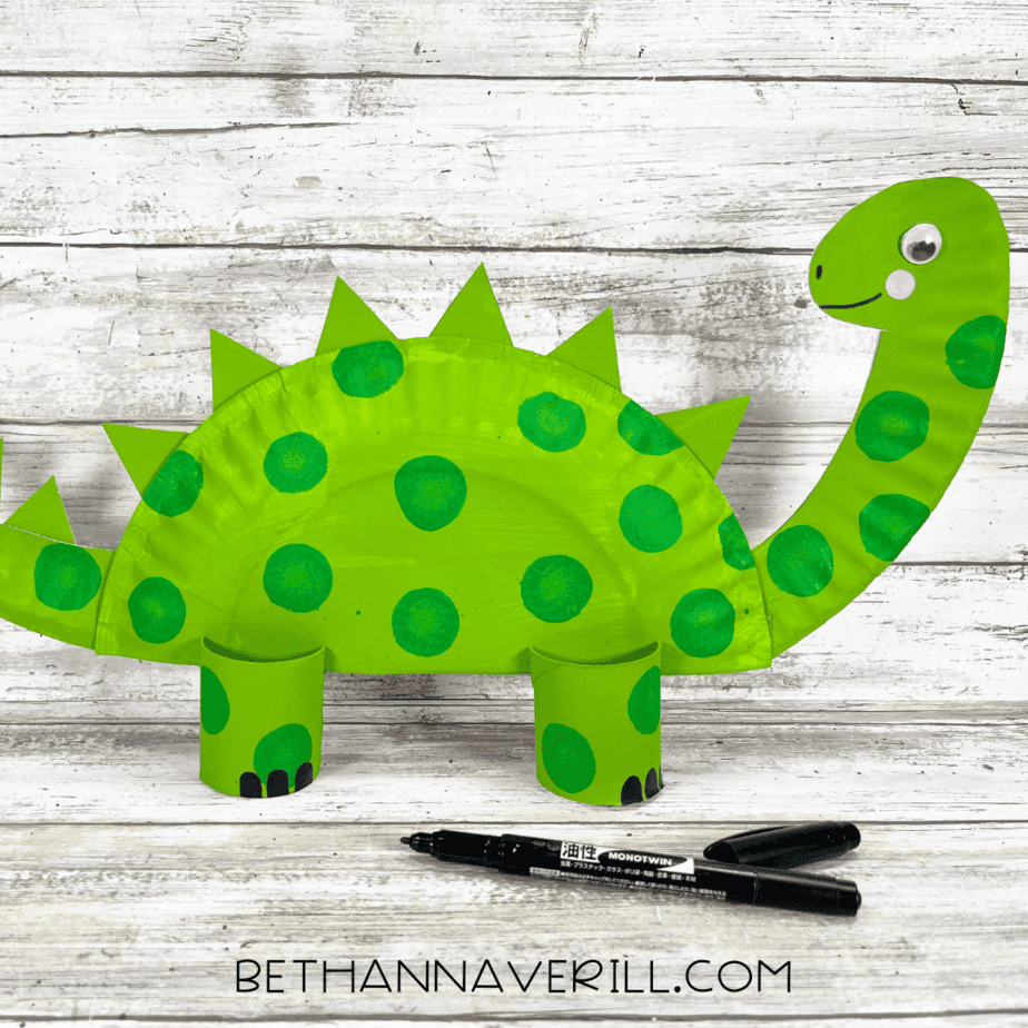 dinosaur paper plate craft with spikes, legs, and face.