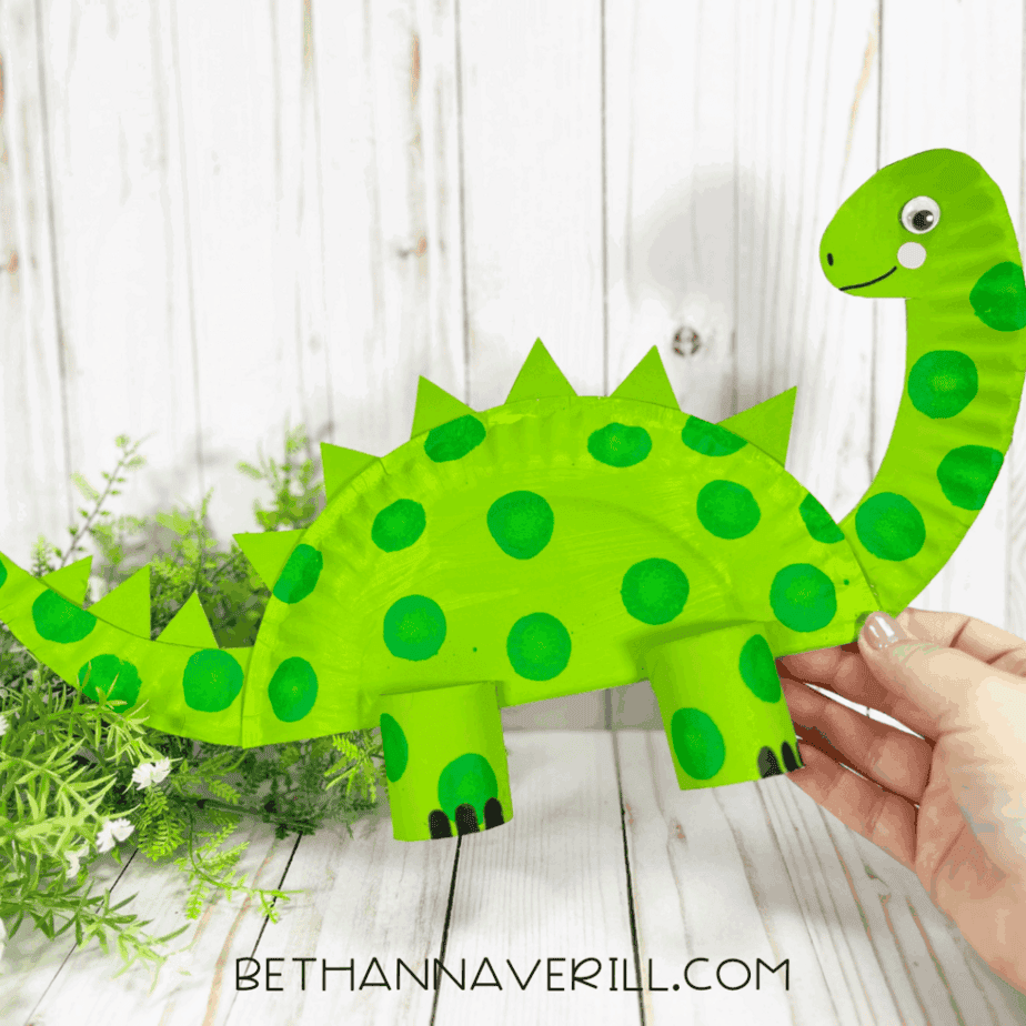 Finished dinosaur craft being held up against a light background.