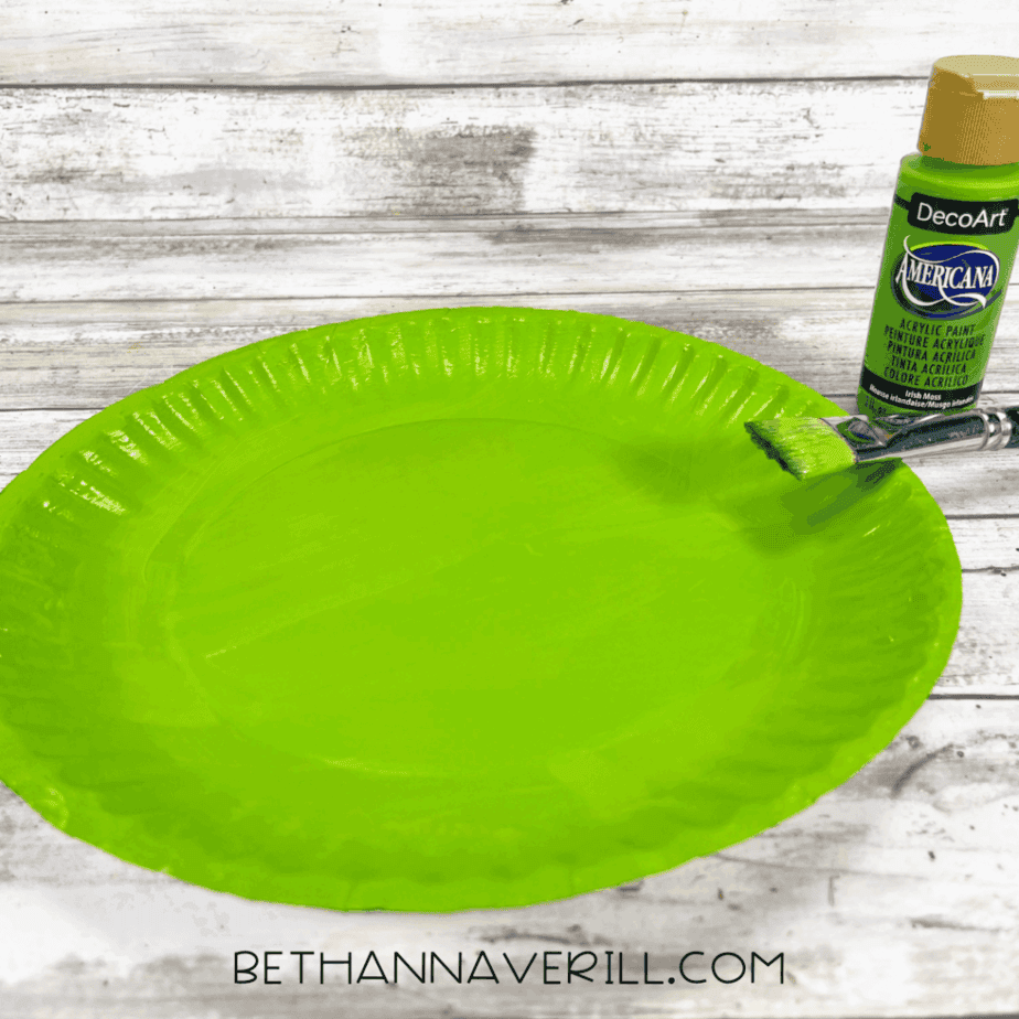 Paper plate painted green with a brush.