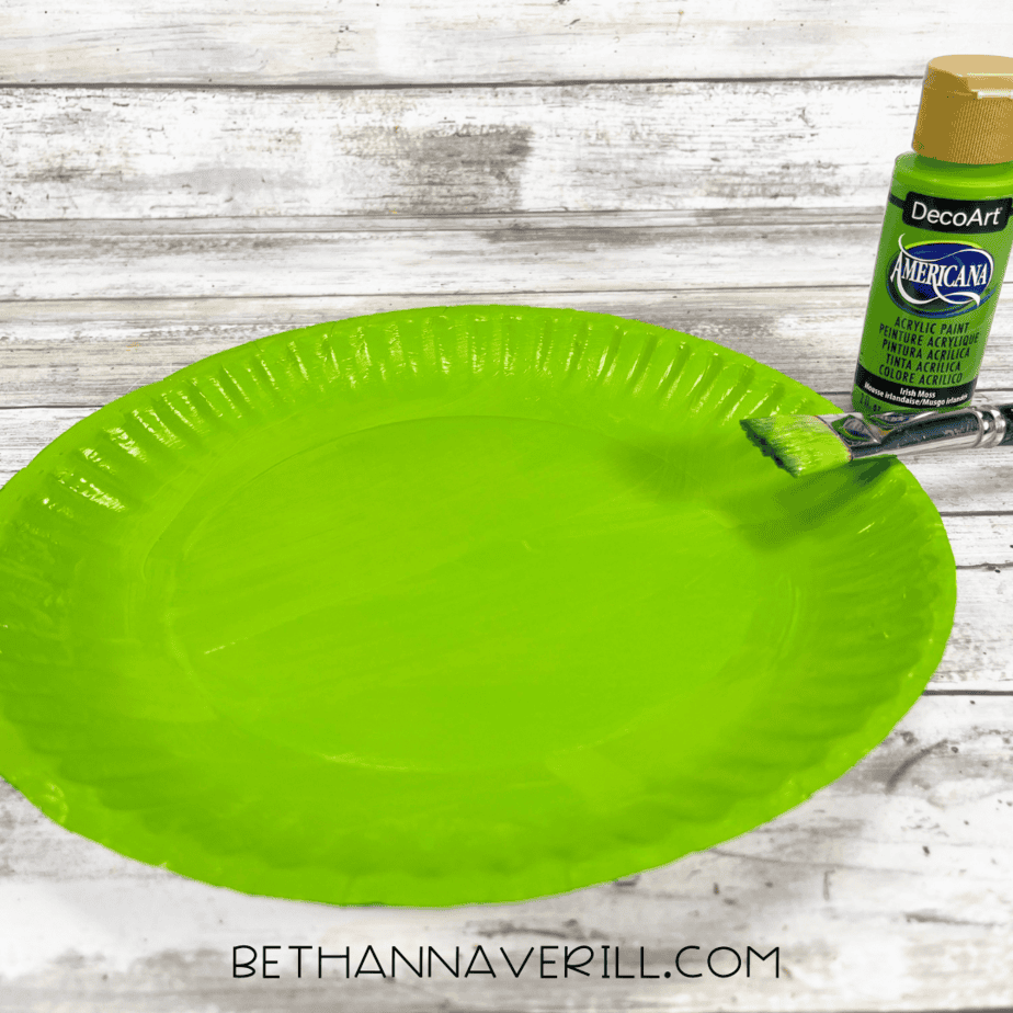 Paper plate painted green with a brush.