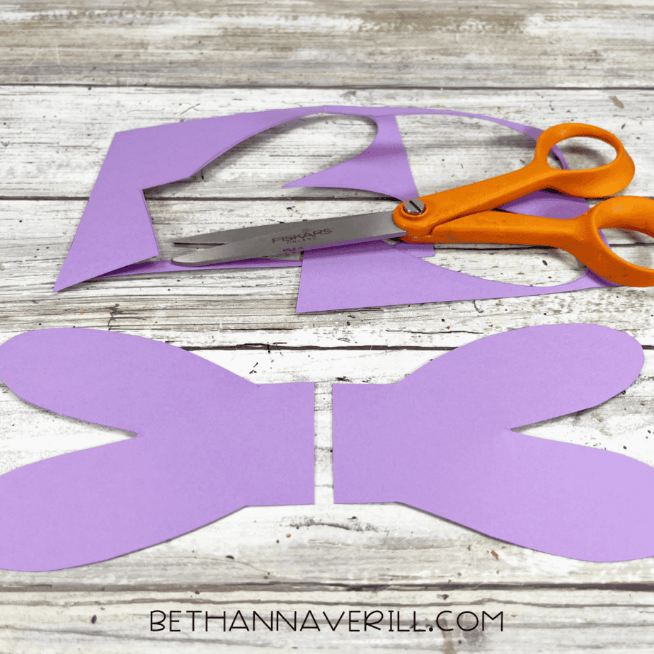 Cut-out purple dragonfly wings with scissors beside them.