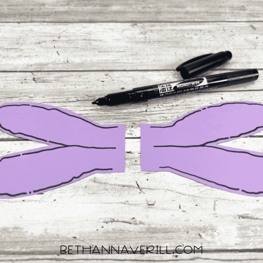 Purple dragonfly wings outlined in black marker for detail.