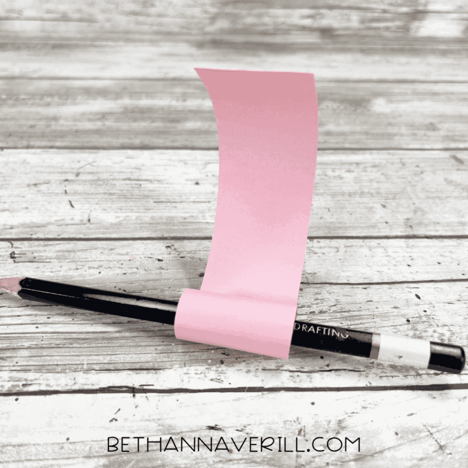 The pink strip of paper wrapped around a pencil to curl it into a tongue shape.