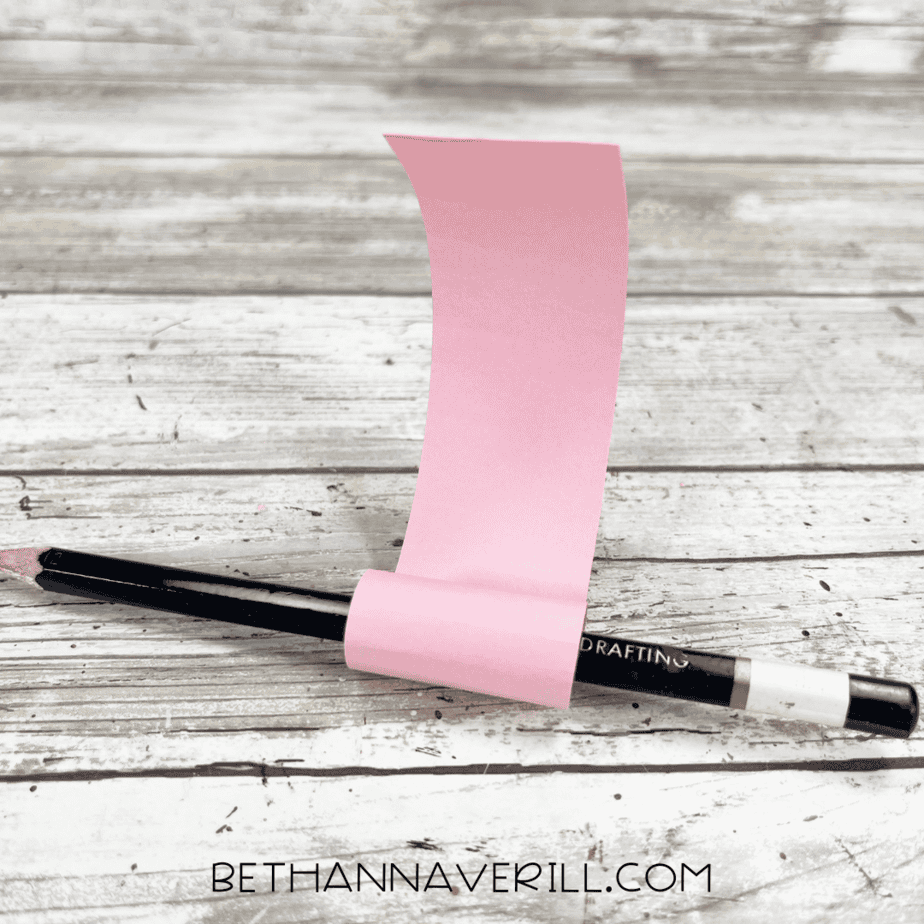The pink strip of paper wrapped around a pencil to curl it into a tongue shape.