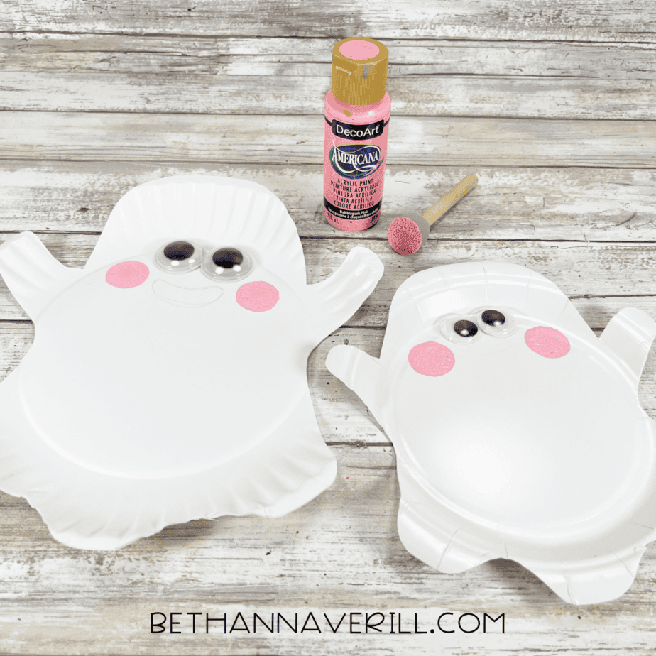 Paper plate ghosts with pink painted cheeks added using a sponge dabber.