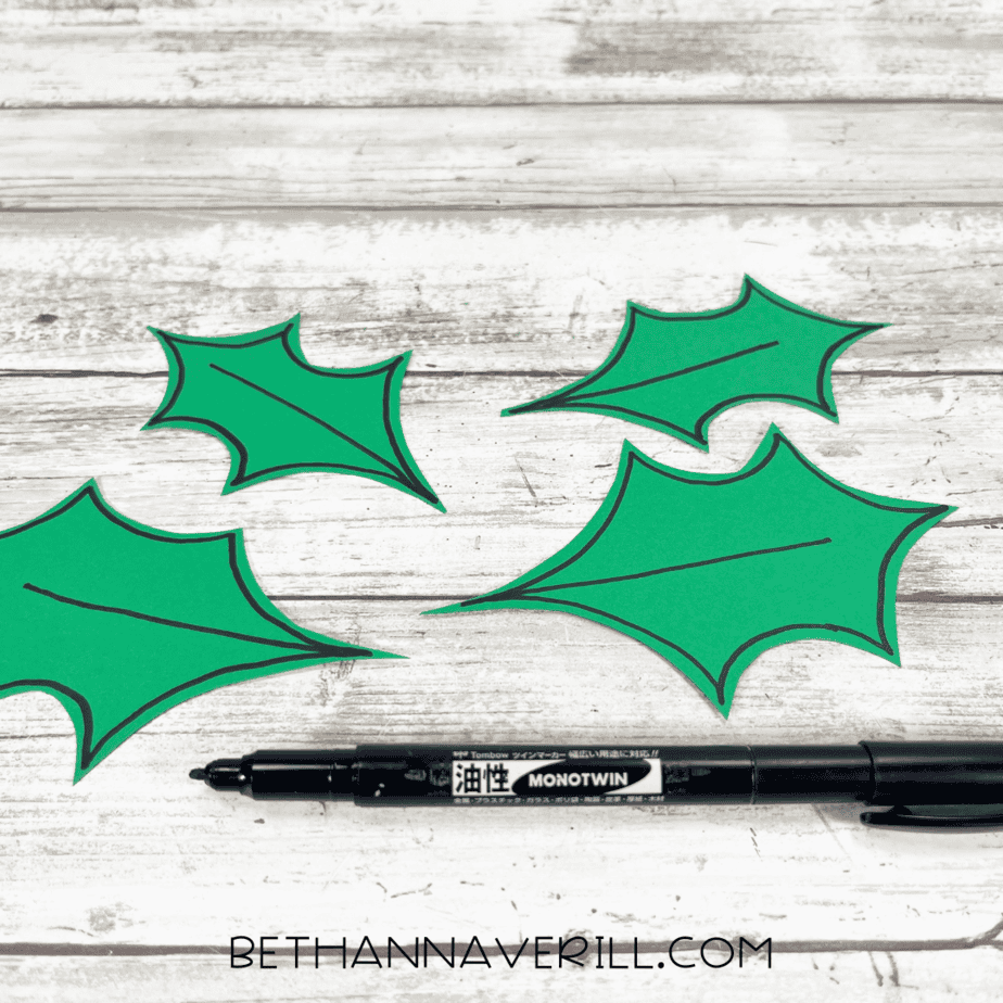 Black marker outlining the holly leaves with veins.