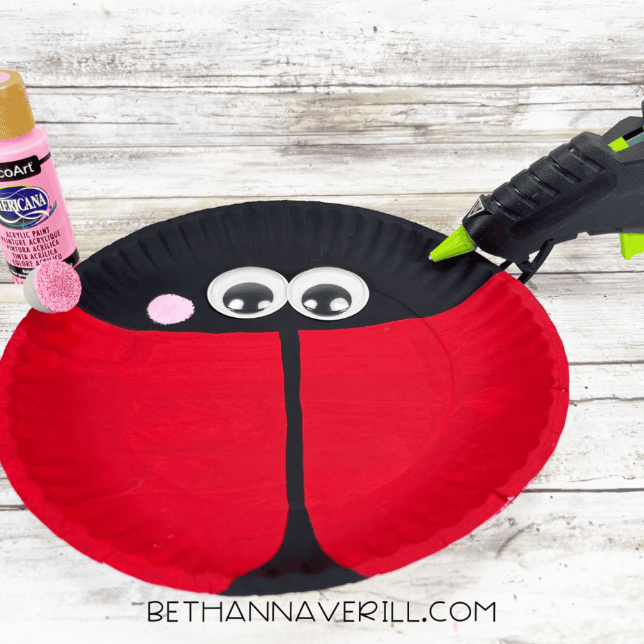 Pink cheeks being added to the ladybug with a sponge dabber.