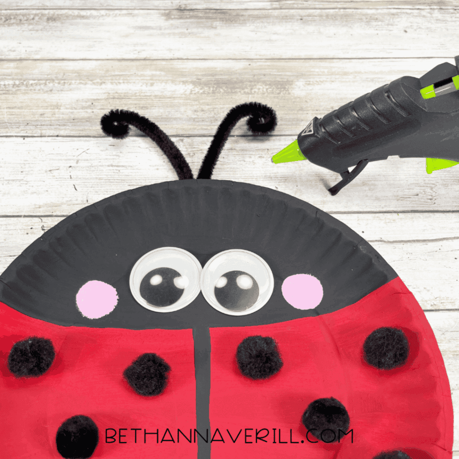 Ladybug paper plate with googly eyes, cheeks, spots, and antennae glued on.
