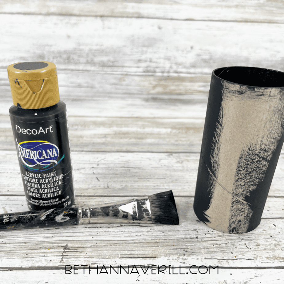Toilet paper roll painted black with acrylic paint.
