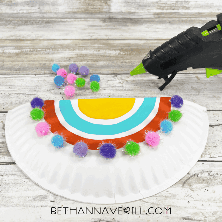 Pom-poms glued along the curved edge of the half paper plate to decorate the saddle.