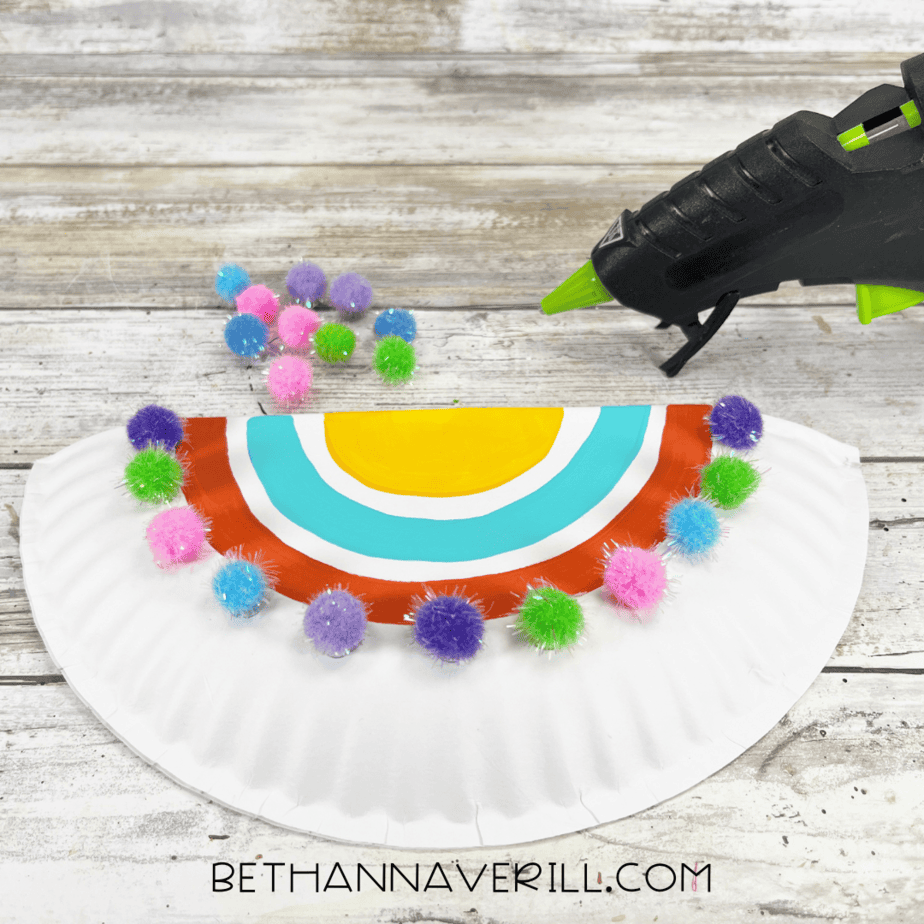 Pom-poms glued along the curved edge of the half paper plate to decorate the saddle.