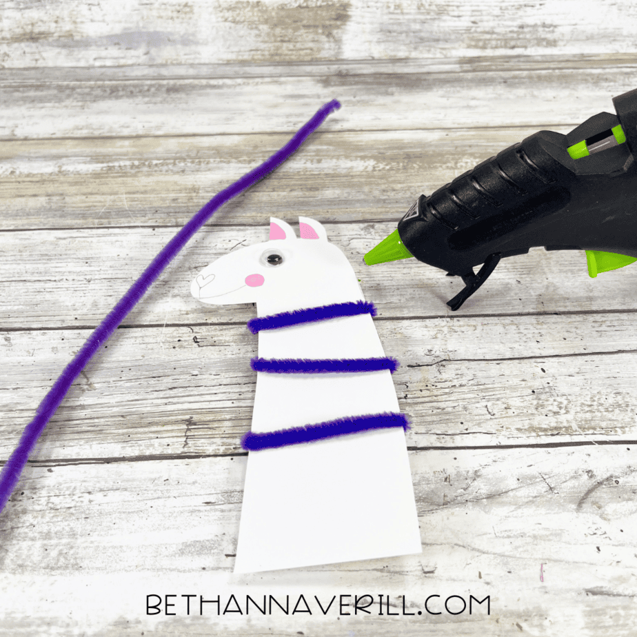 The llama head with a purple pipe cleaner wrapped around the neck.