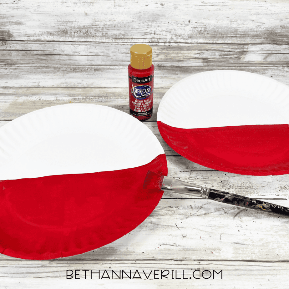 Paper plate painted halfway red for Mickey Mouse craft.