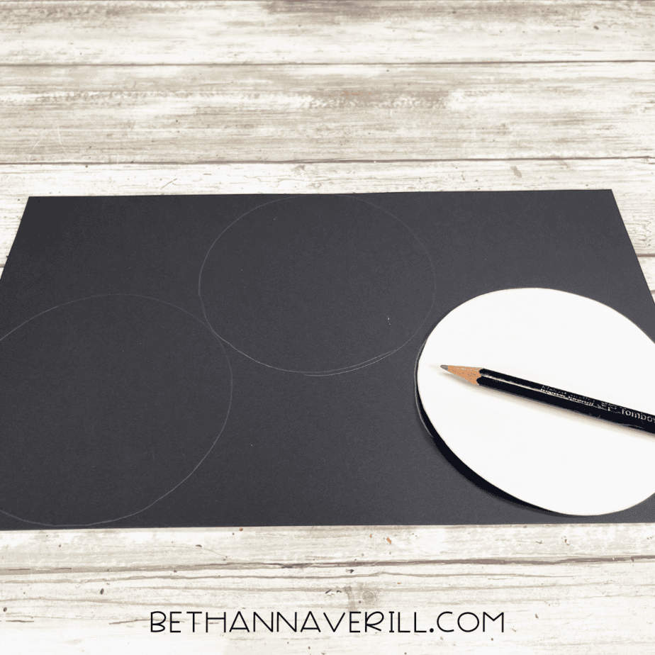 Circles being traced onto black paper for Mickey Mouse ears.