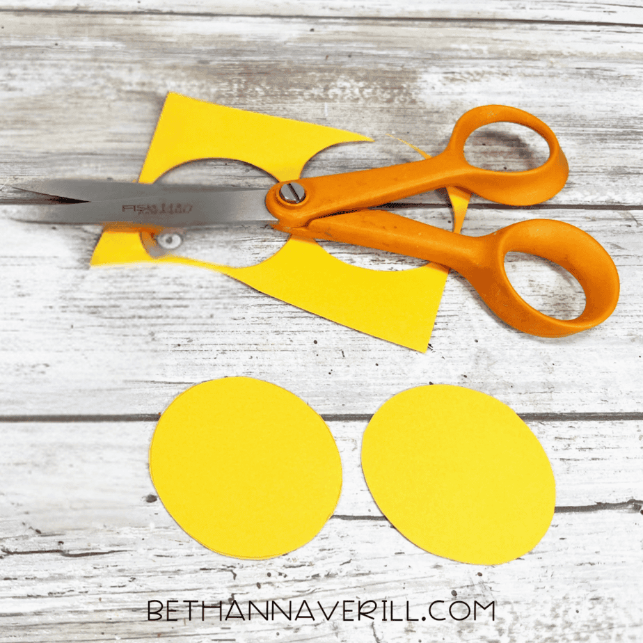 Two yellow paper circles cut out for Mickey Mouse buttons.