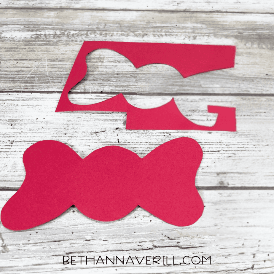 Cut-out red bow shape placed on a table.