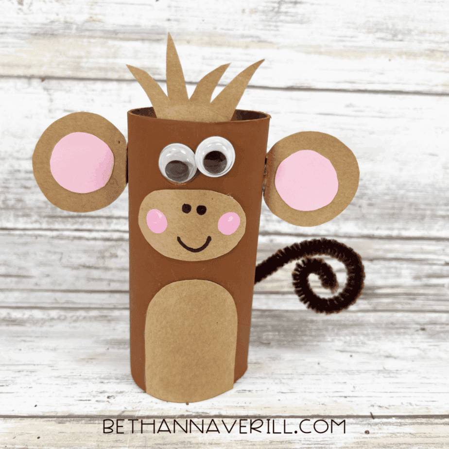 Completed monkey paper roll craft with googly eyes, ears, pink cheeks, and curly tail.