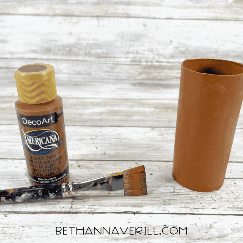 Toilet paper roll painted brown with a paintbrush and brown acrylic paint.