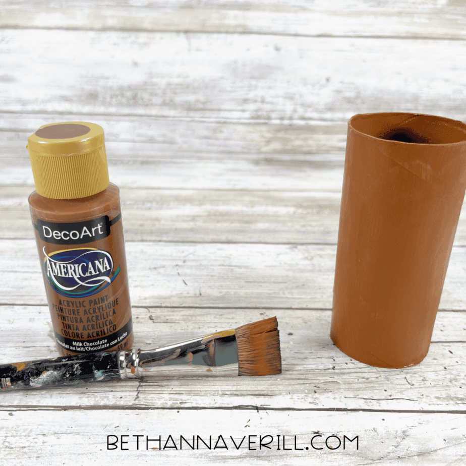 Toilet paper roll painted brown with a paintbrush and brown acrylic paint.