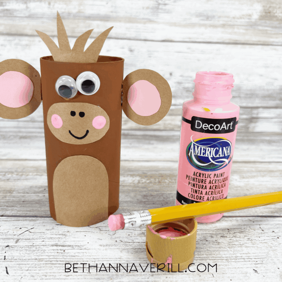 Monkey paper roll craft with googly eyes, pink cheeks, and a painted smile.