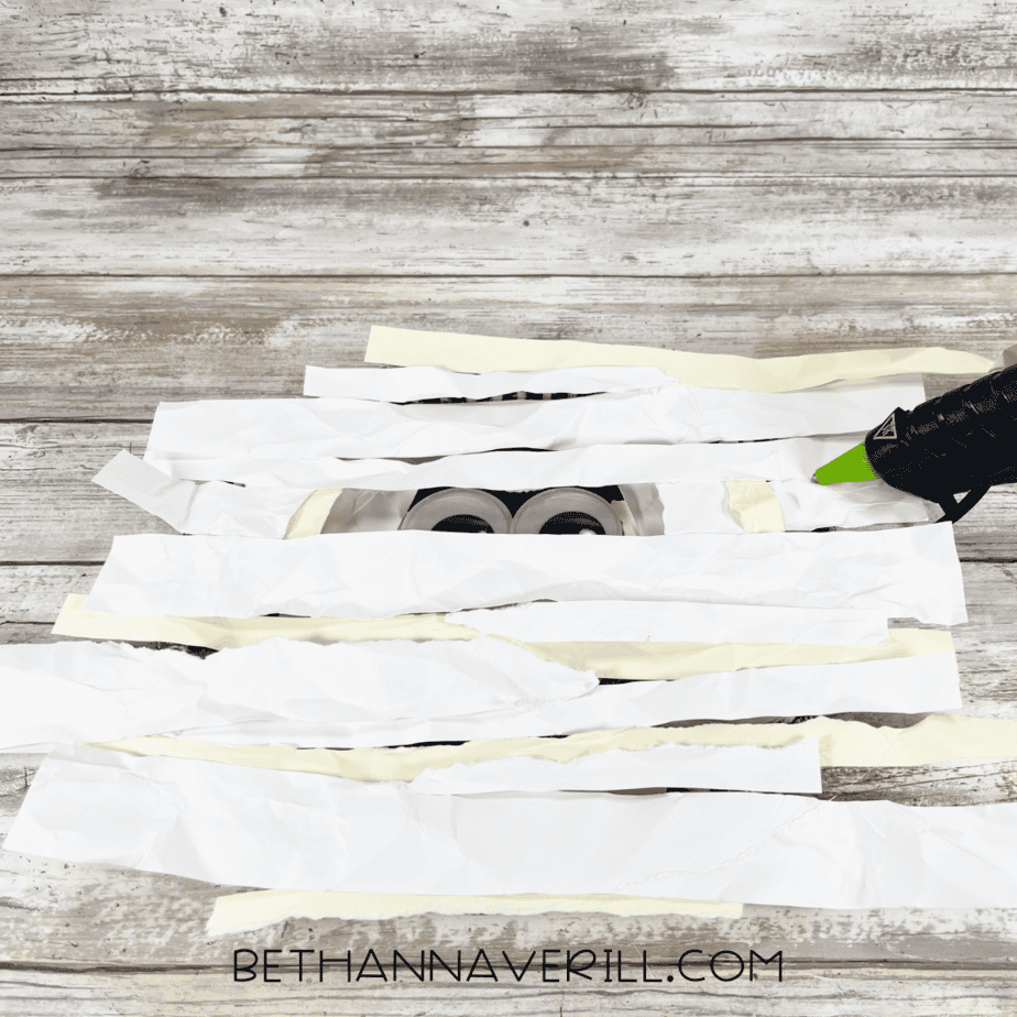 More crumpled strips layered over the black plate to form mummy bandages.