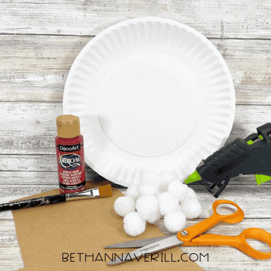 Mushroom paper plate craft supplies including paper plate, red paint, cotton balls, and scissors.