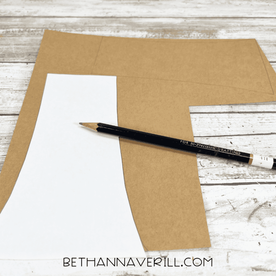 White paper stem template being traced onto brown cardstock with a pencil.