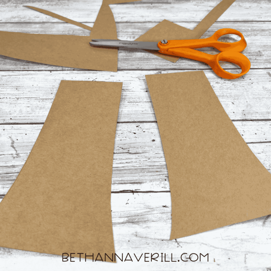 Brown cardstock cut into two mushroom stems with scissors beside them.