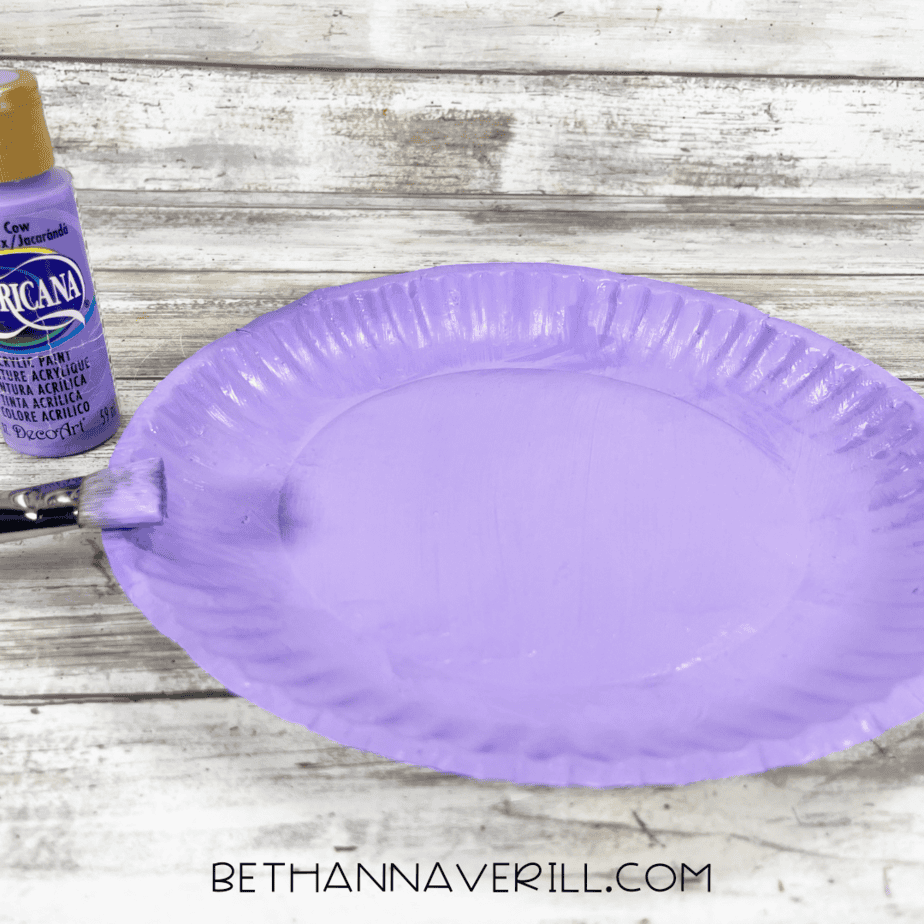Paper plate painted purple for narwhal craft base.
