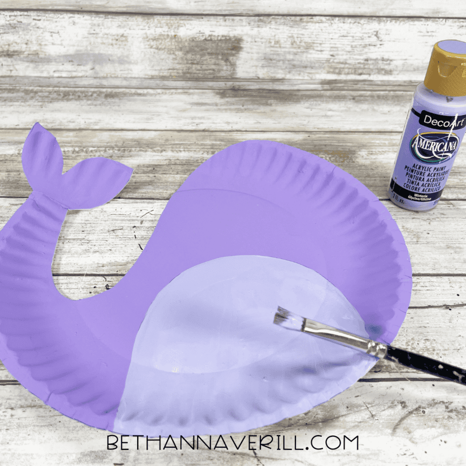 Painting the belly on purple narwhal paper plate.